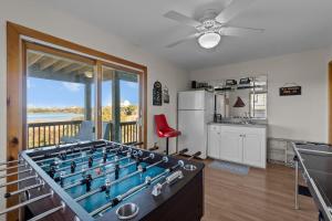 a living room with a pool table and a kitchen at 7200 - Better Surf Than Sorry in Salvo