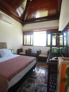 a bedroom with a bed and a desk and windows at Beachfront Studio with Pool Caponga in Cascavel +49 photos