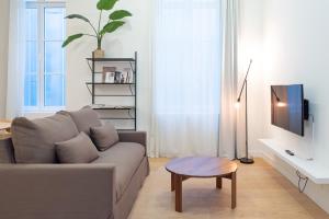 a living room with a couch and a table at The Ghentian Suites by Domani Hotels in Ghent