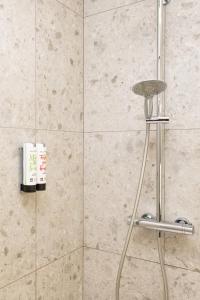 a shower with a stool in a bathroom at The Ghentian Suites by Domani Hotels in Ghent +31 photos