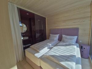 a bed with white sheets and pillows in a room at Jules - Come Together in Stuben am Arlberg