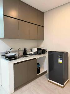 a kitchen with a counter and a sink and a refrigerator at Stay Inn Apartelle in Roxas City