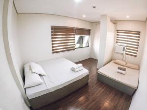 a small bedroom with a bed and a window at Stay Inn Apartelle in Roxas City
