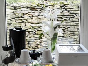 ゴルドにあるラ シェネ ドゥ ゴルドの窓際のテーブルに座る白花瓶
