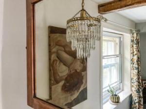 a chandelier hangs above a painting on a wall at 11 The Plosh in Keswick +8 photos