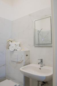 a white bathroom with a sink and a mirror at Modernes Studio im Zentrum mit Parkplatz in Gummersbach