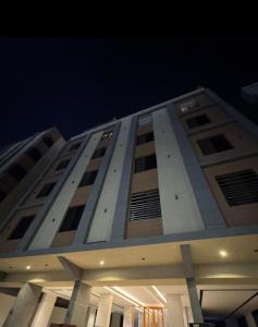 a tall building with many windows at night at The Queen Apartment in Jeddah