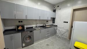 a kitchen with a sink and a washing machine at The Queen Apartment in Jeddah