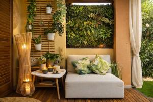 a patio with a chair and a table and plants at Japandi Suites Olbia in Olbia +24 photos
