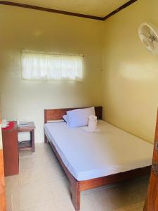 a bedroom with a bed with a pillow and a window at Ayette's Bamboo Cottages in San Vicente