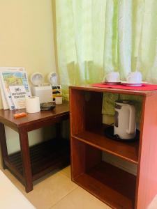 a toy kitchen with two wooden shelves with a coffee maker at Ayette's Bamboo Cottages in San Vicente
