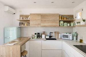 a kitchen with white cabinets and a counter top at Japandi Suites Olbia in Olbia