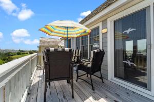 a porch with two chairs and an umbrella at 5592 - Windjammer in Nags Head +48 photos