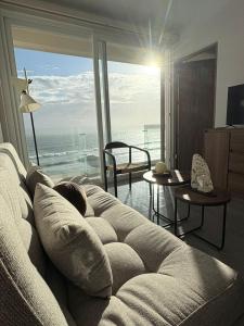 ein Wohnzimmer mit Sofa und Meerblick in der Unterkunft Frente a la Playa con acceso directo AC Alberca y Elevador in Veracruz