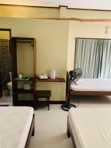 a room with two beds and a desk and a mirror at Ayette's Bamboo Cottages in San Vicente +11 photos