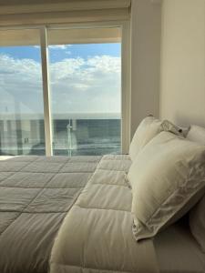 ein Schlafzimmer mit einem großen Bett und einem großen Fenster in der Unterkunft Frente a la Playa con acceso directo AC Alberca y Elevador in Veracruz + 58 Fotos