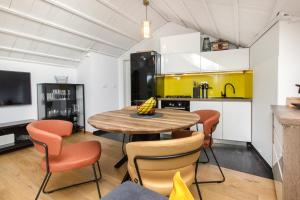 a kitchen and dining room with a wooden table and chairs at Dalmatian stone Villa Burica in Vinišće