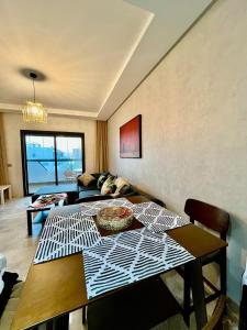 a living room with a table and a couch at Chic studio with sea view, Wi-Fi & pool in Aïn Harrouda