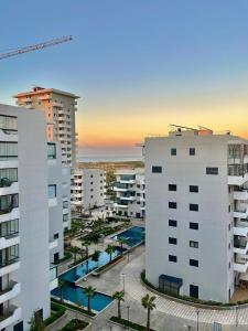 an aerial view of two buildings and a pool at Chic studio with sea view, Wi-Fi & pool in Aïn Harrouda