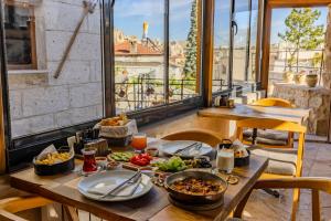 a table with food on it in a room with windows at Lubberona Cave Cappadocia in Nar