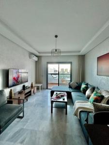 a living room with a blue couch and a table at Chic studio with sea view, Wi-Fi & pool in Aïn Harrouda