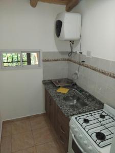 a kitchen with a sink and a stove top oven at Descanso en Salsipuedes in Salsipuedes