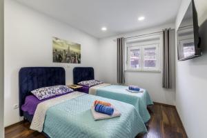 two beds in a room with blue and purple at Villa Little Heaven in Split +46 photos