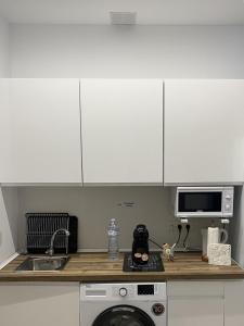 a kitchen with white cabinets and a washing machine at Santa Pola Suites - Self Check-in near Beach in Santa Pola