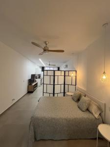 a bedroom with a bed and a ceiling fan at Santa Pola Suites - Self Check-in near Beach in Santa Pola