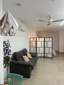 a living room with a couch and a ceiling fan at Santa Pola Suites - Self Check-in near Beach in Santa Pola