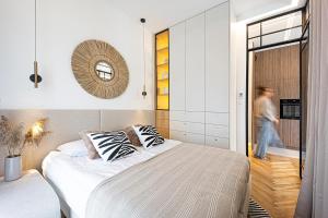 a man walking into a bedroom with a large bed at Porto Marina - widok na jezioro z każdego z 3 pokoi, lux, garaż, klima in Iława