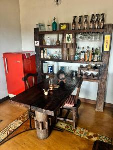 a room with a wooden table and a red refrigerator at Recanto do Sitio in Tiradentes
