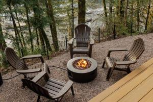 a group of chairs sitting around a fire pit at Roaring River Lodge Riverfront Fire pit EV Plug in Rhododendron