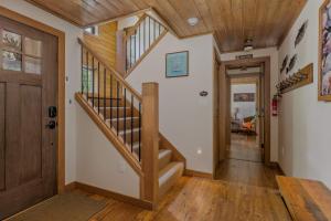 a hallway with a wooden door and stairs in a house at Roaring River Lodge Riverfront Fire pit EV Plug in Rhododendron +60 photos