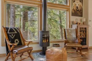 a living room with two chairs and a wood stove at Roaring River Lodge Riverfront Fire pit EV Plug in Rhododendron