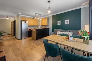 a kitchen and living room with a table and a couch at SECOND HOME Lubawa - 3 pokoje, 5 łóżek, Netflix i Max, parking, winda in Lubawa