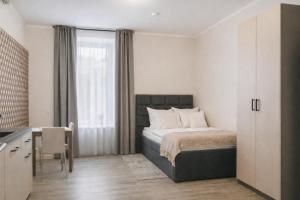 a bedroom with a bed and a table and a kitchen at Modernes Studio im Zentrum mit Parkplatz in Gummersbach