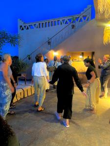 a group of people walking around a room holding hands at Dar Talmoudi ,Traditional Riad, Local Food, Camel , Desert Excursions in Tagounite