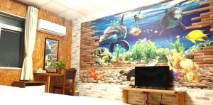 a bedroom with a mural on the wall at 十畝田山莊 in Chishang