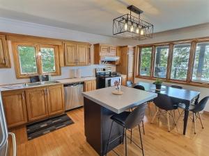 a kitchen with wooden cabinets and a table and chairs at Sir'Eau d'Érable in St-Ferdinand