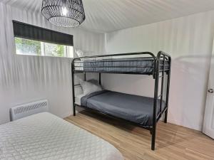 a bedroom with two bunk beds and a chandelier at Sir'Eau d'Érable in St-Ferdinand