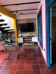a patio with two chairs and a television on a wall at Casa Roma in Rivera