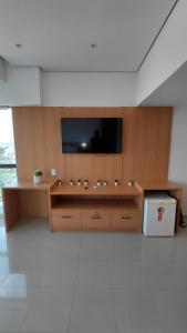 a living room with a television on a wooden wall at Tropical Executive Hotel Flat 205 in Manaus