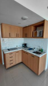 a kitchen with wooden cabinets and a sink at Tropical Executive Hotel Flat 205 in Manaus