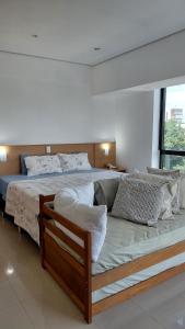 a bedroom with a large bed with white sheets and pillows at Tropical Executive Hotel Flat 205 in Manaus +29 photos