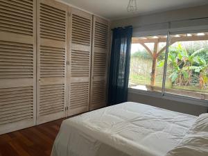 a bedroom with wooden closets and a bed and a window at Bidart centre maison vue mer in Bidart
