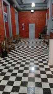 a black and white checkered floor in a room with chairs at Hostel Las Lengas in Buenos Aires