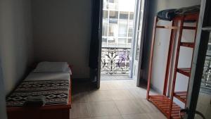a room with a bed and a door with a balcony at Hostel Las Lengas in Buenos Aires