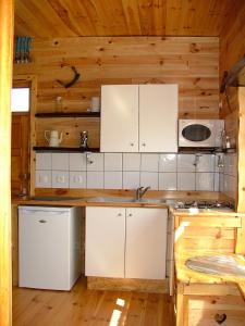 una cocina con armarios blancos y un lavabo en una cabaña en studio MONT LOUIS, en La Cabanasse