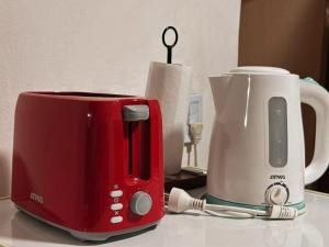 a red toaster and a coffee maker on a counter at En Armonía in Tinogasta